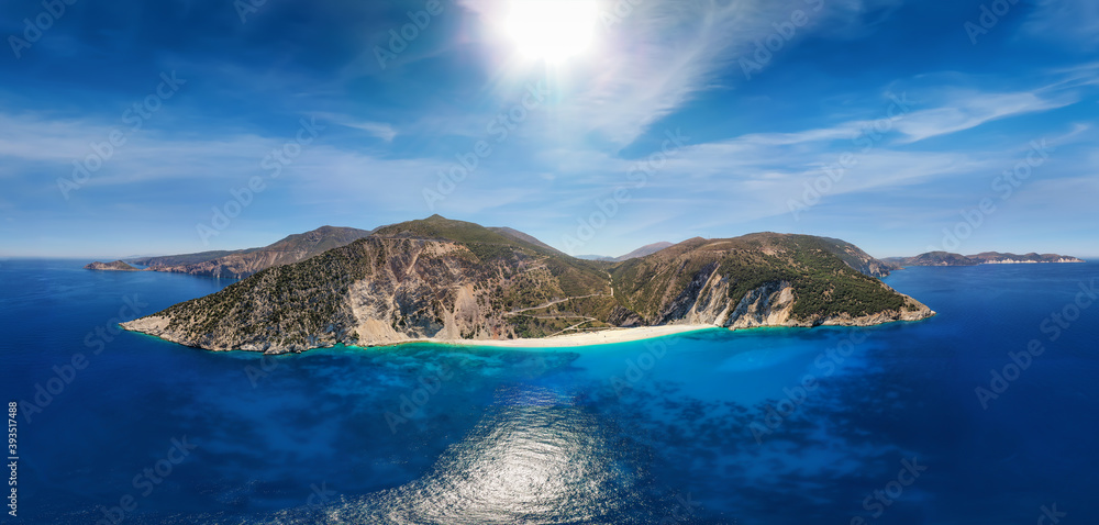 Wide aerial panoramic view to the popular beach of Myrtos on the Ionian island of Kefalonia, Greece, with turquoise sea and sunshine during summer time