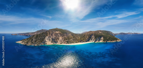 Wide aerial panoramic view to the popular beach of Myrtos on the Ionian island of Kefalonia  Greece  with turquoise sea and sunshine during summer time