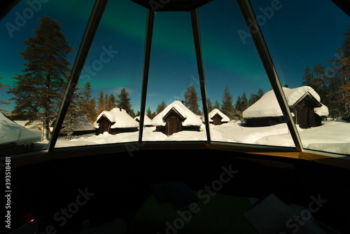 Aurora Borealis through the window of the igloo cabin in Finland Lapland. Arctic circle Christmas winter adventure, good luck and happiness 