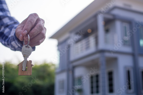 Homeowner holding a new house key from a broker after agreeing to buy a mortgage-home investment. Concept buying a house , a new home.