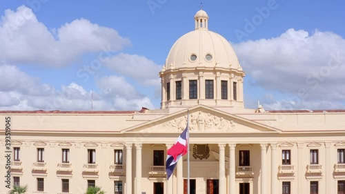 Dominican Republic flag waving at the national palace on a sunny day, shot from low altitude with drone photo