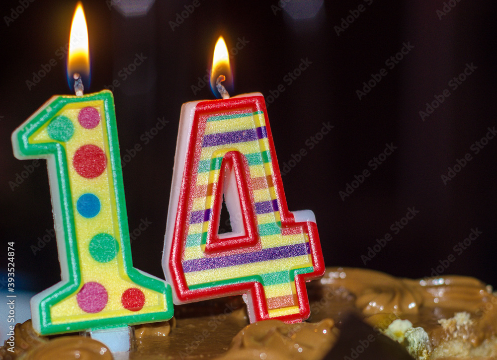 figure 14. colored candles were lit on chocolate cake. Birthday of  teenager. Stock Photo | Adobe Stock