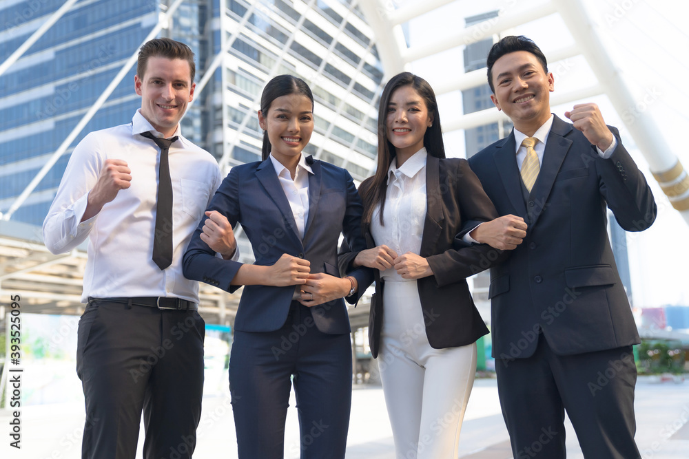 Four executives in a row, Business team standing and cheering in front of modern office, Leadership Concept Four executives in a row, Business team standing and cheering in front of modern office, Leadership Concept