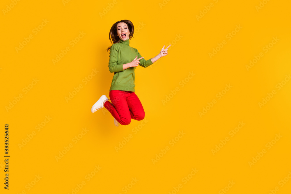 Obraz premium Full size photo of funny lady jump upshow novelty empty space wear casual pullover trousers isolated yellow color background