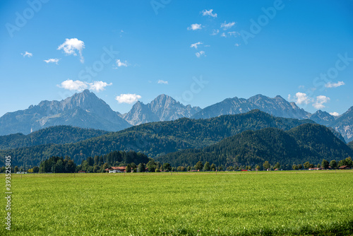 Green Agricultural Fields and Bavarian Alps with the small town of Schwangau near Fussen, Ostallgau, Bavaria, Germany.