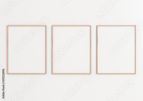 Three Vertical 8x10 Rose Gold Frames Mockup. Three Vertical Rose Gold Frames on a white wall.