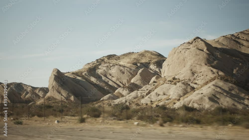 California Nature next to a higway with yellow road sign, Driving past brown beige rocks and sand California Nature next to a higway with yellow road sign, Driving past brown beige rocks and sand