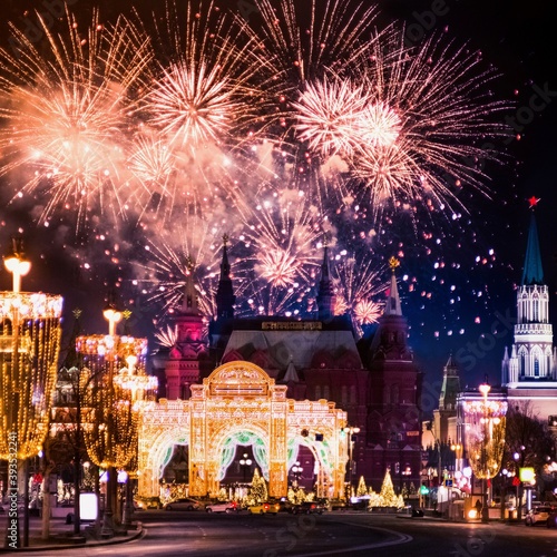 Festive salute and fireworks on the red square in Moscow. Salute lights over the Kremlin and GUM at the New Year celebration. Multicolored salute for Christmas in Moscow at night, Russia #393532241