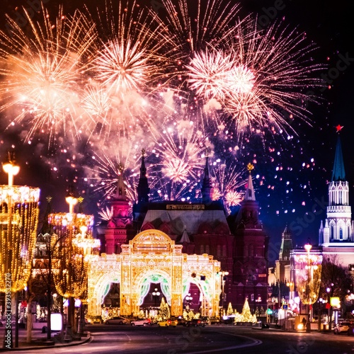 Festive salute and fireworks on the red square in Moscow. Salute lights over the Kremlin and GUM at the New Year celebration. Multicolored salute for Christmas in Moscow at night, Russia #393532270