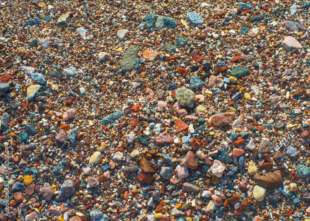 Wet colored pebbles on a beach in the surf Wet colored pebbles on a beach in the surf