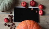 Food ordering. Top view. Online recipe. A tablet with black blank screen on an wood desk. Apple, pumkin in autumn.