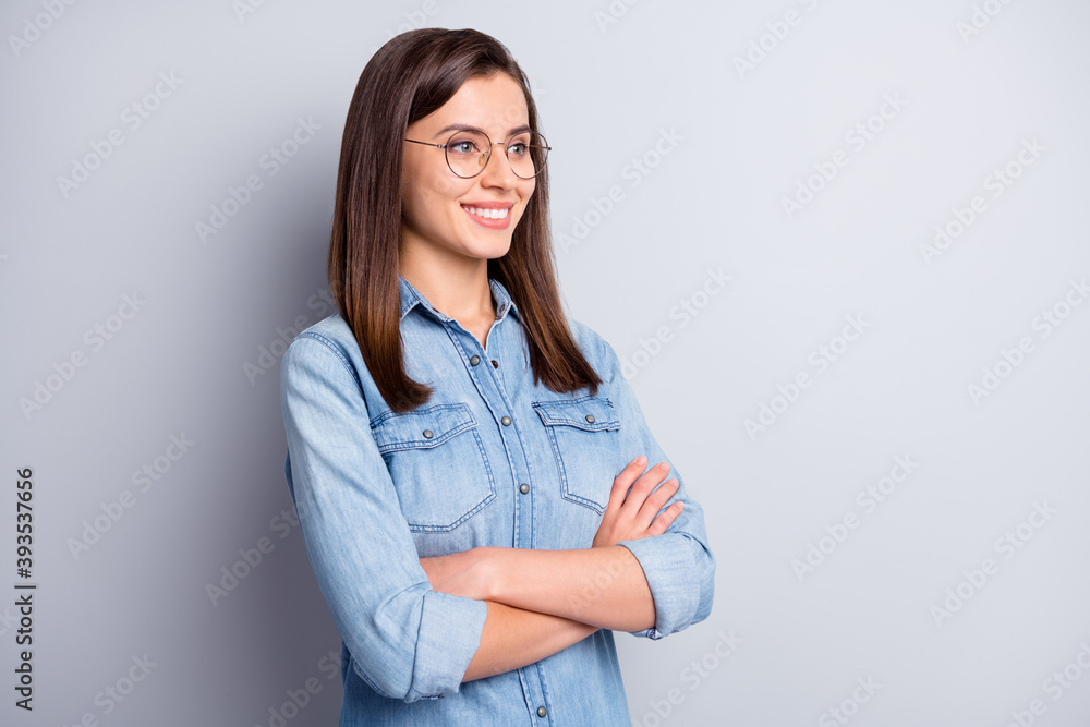 Portrait of attractive confident young woman crossed hands look empty space wear glasses isolated on grey color background Portrait of attractive confident young woman crossed hands look empty space wear glasses isolated on grey color background