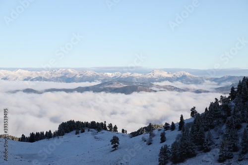 Fototapeta Naklejka Na Ścianę i Meble -  Snowy mountains covered in clouds beautified by the sky
