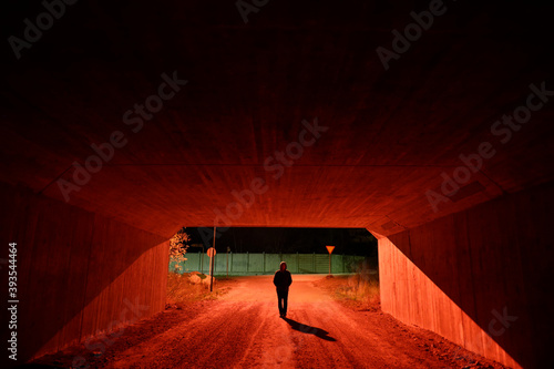 Photography Stockholm, Sweden A man walks through a red-lit pedestrian tunnel