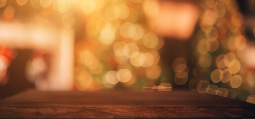 Beautiful blurred Christmas background. In the foreground is a wooden table. In the background there is a Christmas tree and a fireplace