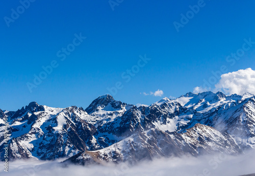 Snow and mountain peaks in the french Pyrenees near the Luchon Superbagnères Ski Resort in the Arrondissement of Saint-Gaudens, Occitania, Haute-Garonne, France. The Luchonnais Mountains aerial view. © An Instant of Time