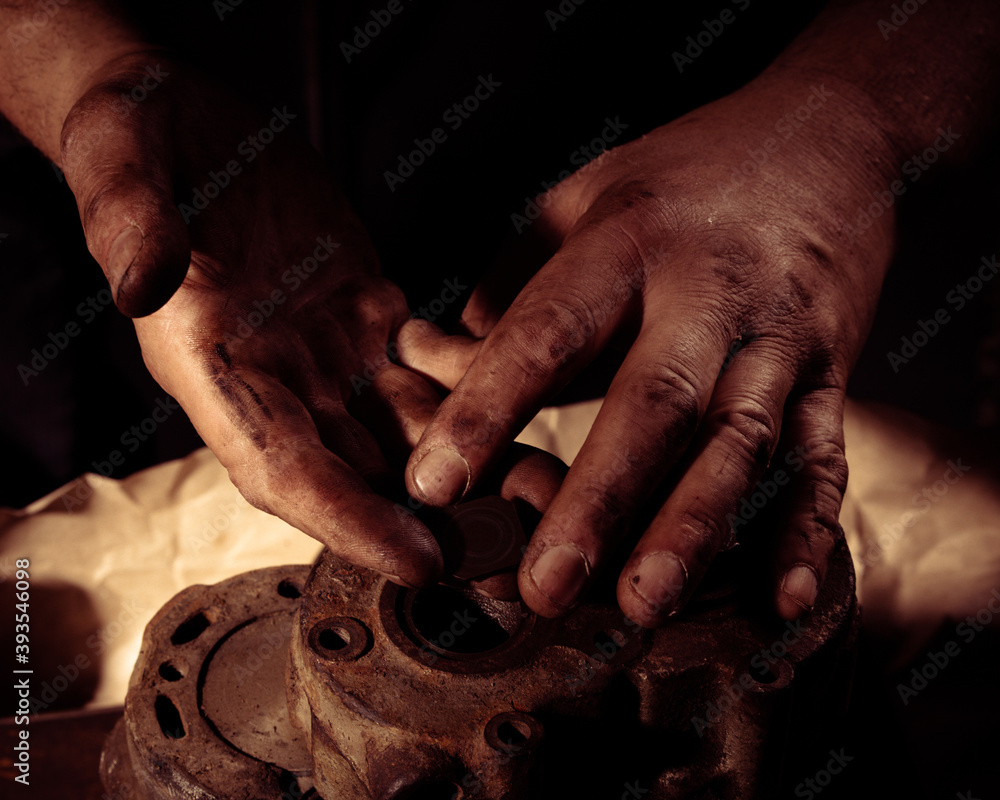 Close-up of the hand of a man who makes repairs to the old mechanism