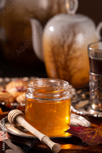 Tasty honey stick and a glass jar