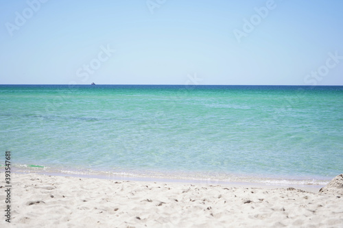 Beautiful sea view of the azure sea on a Sunny summer day on a sandy beach. © Ekaterina_1525