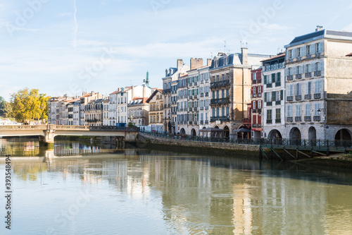 views of nive river in bayonne with traditional houses at background