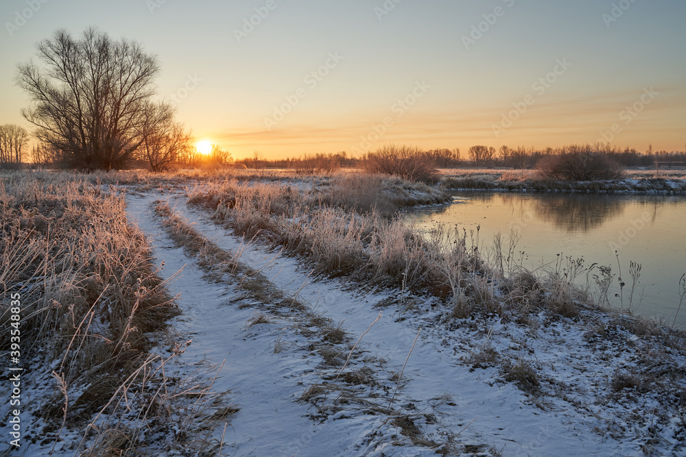 Breath of winter, first ice on the lake, dawn on a frosty morning with frost on the grass, close-up of frost, patterns on the first ice. Breath of winter, first ice on the lake, dawn on a frosty morning with frost on the grass, close-up of frost, patterns on the first ice.