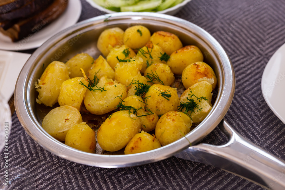 toasted young potatoes with dill in metal skillet toasted young potatoes with dill in metal skillet