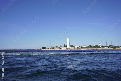 Boat trip on the sea past the lighthouse on the coast. Family on a boat trip. Turquoise water and blue sky on a Sunny day. White lighthouse against the blue sea and blue sky. July 25, 2020: Crimea