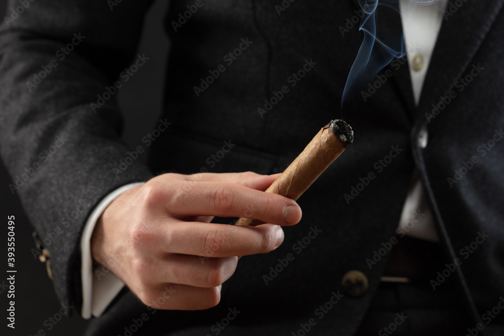 The Man'S Hand Holds A Smoking Cigar