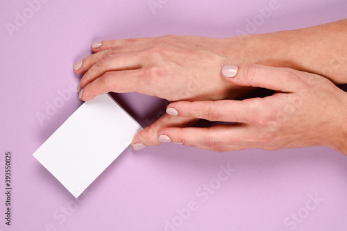 Female hands with cutaway, blank menu, discount card, business card on color pink beauty background with copy space. Template for design Mockup