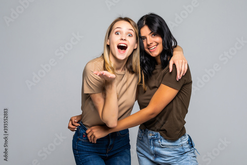 Excited young women having fun together talking and laughing isolated on white background