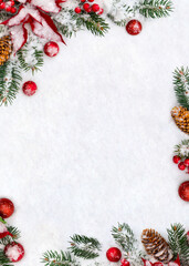 Christmas decoration. Frame of branches christmas tree, flower of red poinsettia, brown natural spruce cones, red ball, red berries on snow with space for text. Top view, flat lay