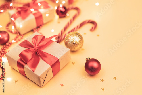 Christmas and New Year blurred backdrop with copy space. Festively decorated  Gift boxes,  cane lollypops, christmas balls on golden background.