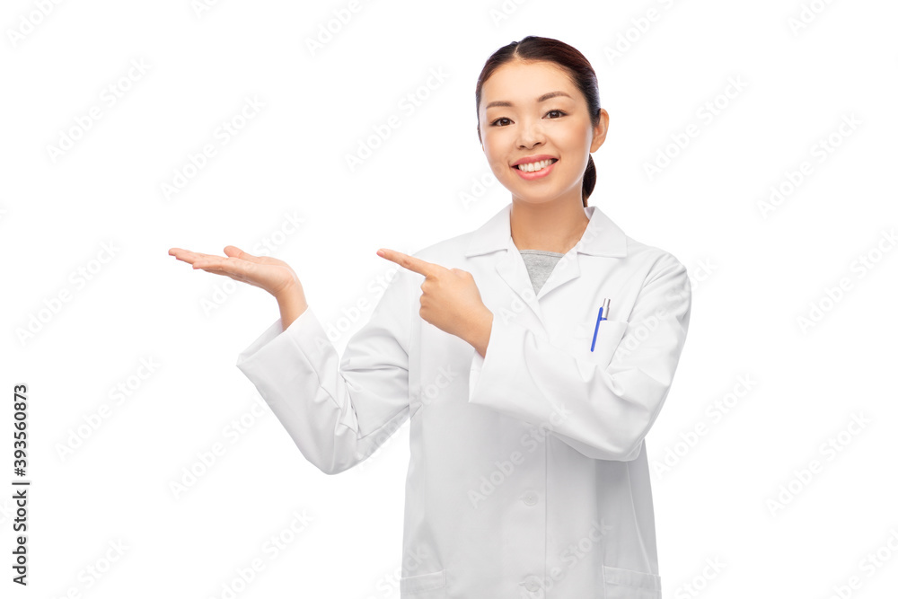medicine, profession and healthcare concept - happy smiling asian female doctor in white coat holding something invisible on her hand medicine, profession and healthcare concept - happy smiling asian female doctor in white coat holding something invisible on her hand