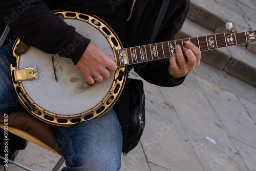 Closeup shot of a street musician playing the bandurria photo