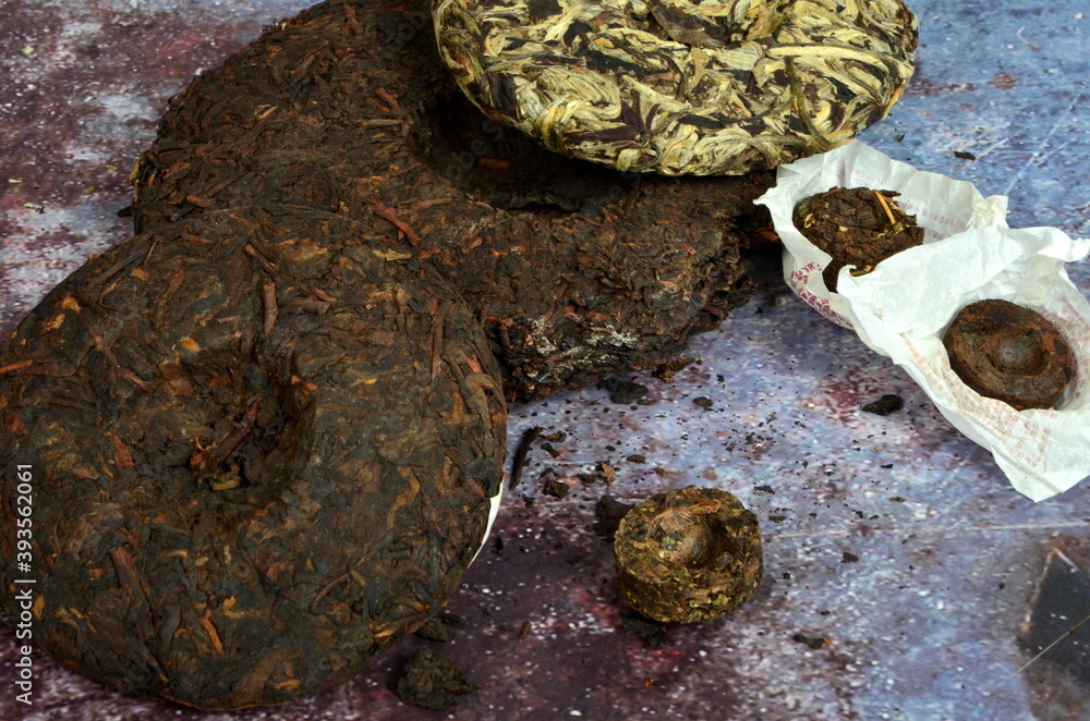 Pressed round pancakes and bricks of puer tea of different kinds. Dry Chinese puer tea of high quality. Pressed round pancakes and bricks of puer tea of different kinds. Dry Chinese puer tea of high quality.