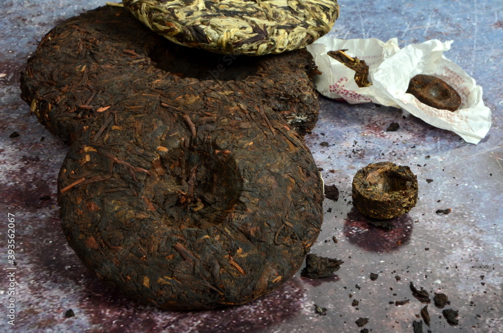 Pressed round pancakes and bricks of puer tea of different kinds. Dry Chinese puer tea of high quality.