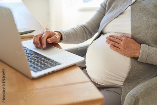 Foto Schwangere Frau beim Arbeiten mit Laptop