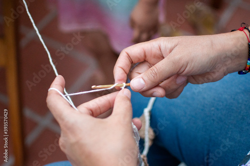 woman s hands knitting with wool and crochet needles