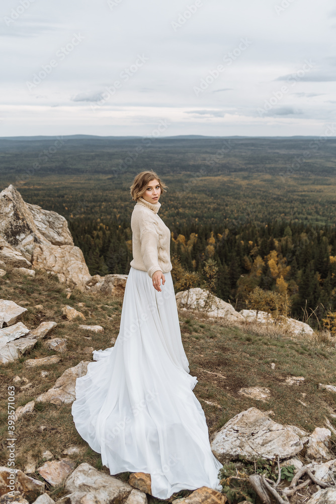 beautiful bride in a white long dress on the mountain. beautiful area for a wedding beautiful bride in a white long dress on the mountain. beautiful area for a wedding