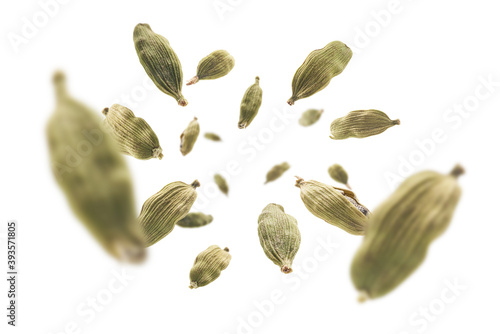 Cardamom pods levitate on a white background