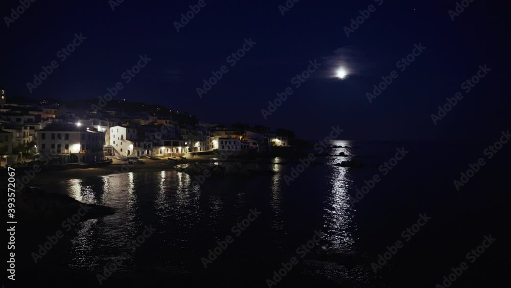 Beautiful Mediterranean village at evening. Night views on a small town on a sea coast. Water and lights of Calella de Palafrugell in Spain. Costa Brava vacation an chill. White houses on the beach.. Beautiful Mediterranean village at evening. Night views on a small town on a sea coast. Water and lights of Calella de Palafrugell in Spain. Costa Brava vacation an chill. White houses on the beach..