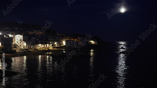 Beautiful Mediterranean village at evening. Night views on a small town on a sea coast. Water and lights of Calella de Palafrugell in Spain. Costa Brava vacation an chill. White houses on the beach..