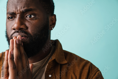 Focused african american man posing with palms together