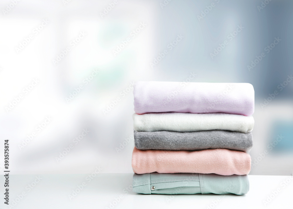 Soft colors stack of clothing,clothes folded on table empty copy space background.Garment stacked. Soft colors stack of clothing,clothes folded on table empty copy space background.Garment stacked.