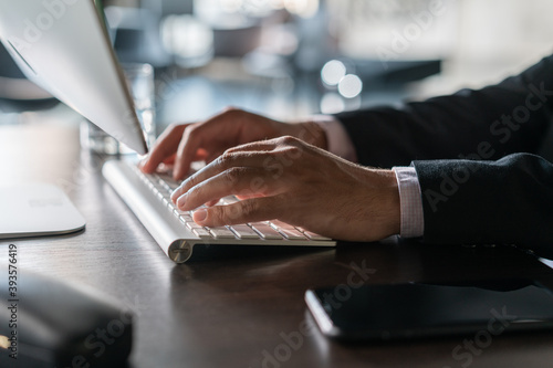 Office manager male hands typing on computer keyboard, closeup. Businessman working, typing on the wireless keyboard, no face, concept of office work