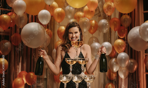 Smiling woman with pyramid of champagne photo