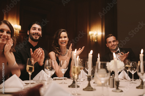 High society people clapping hands at dinner party photo