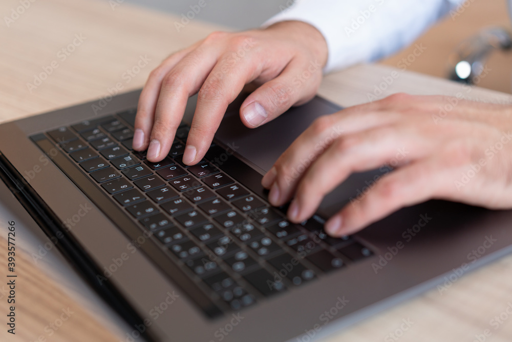 Top view of male hands office manager typing on laptop, closeup of man hands on black keyboard. Man office manager working with computer, no face. Concept of work Top view of male hands office manager typing on laptop, closeup of man hands on black keyboard. Man office manager working with computer, no face. Concept of work