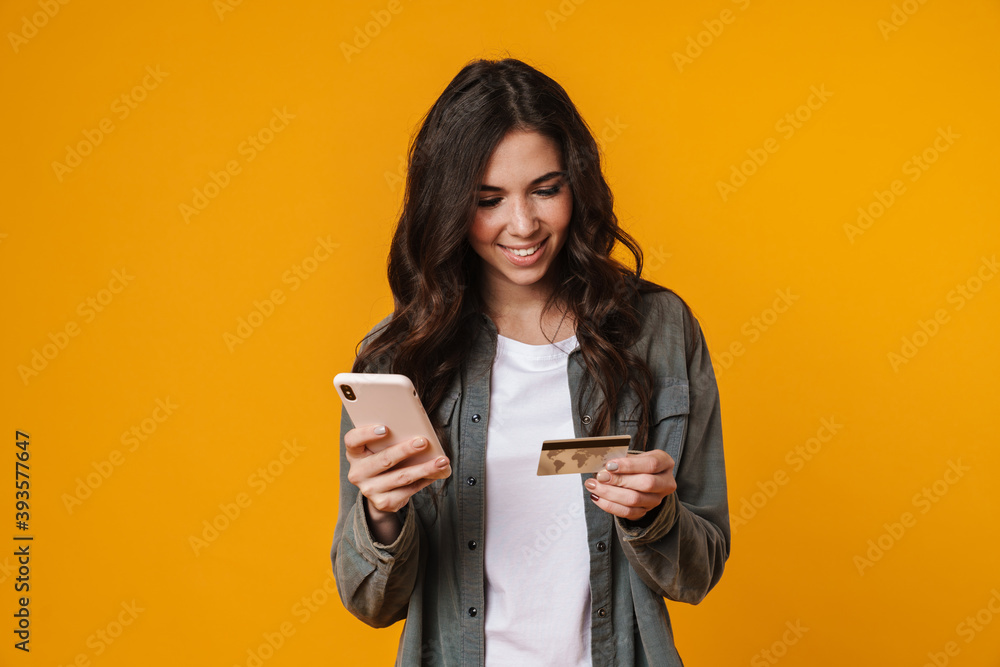 Happy beautiful nice girl holding credit card and mobile phone Happy beautiful nice girl holding credit card and mobile phone