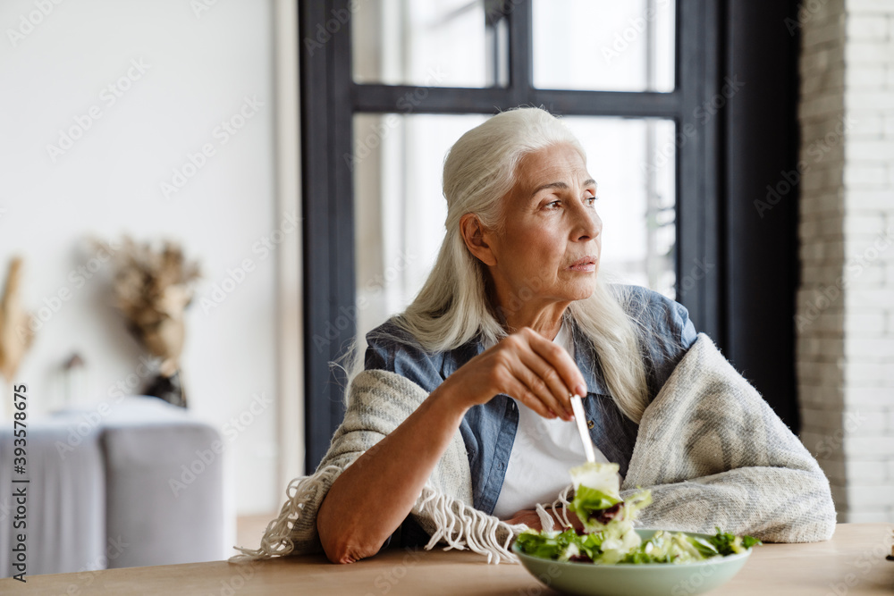 Modern grandmother eating fresh green salad